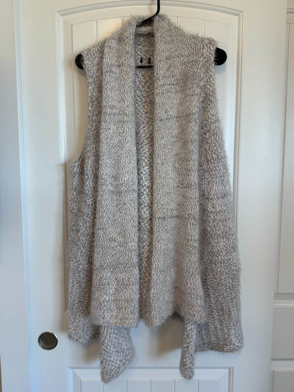 Soft sleeveless open-front cardigan featuring a textured popcorn knit